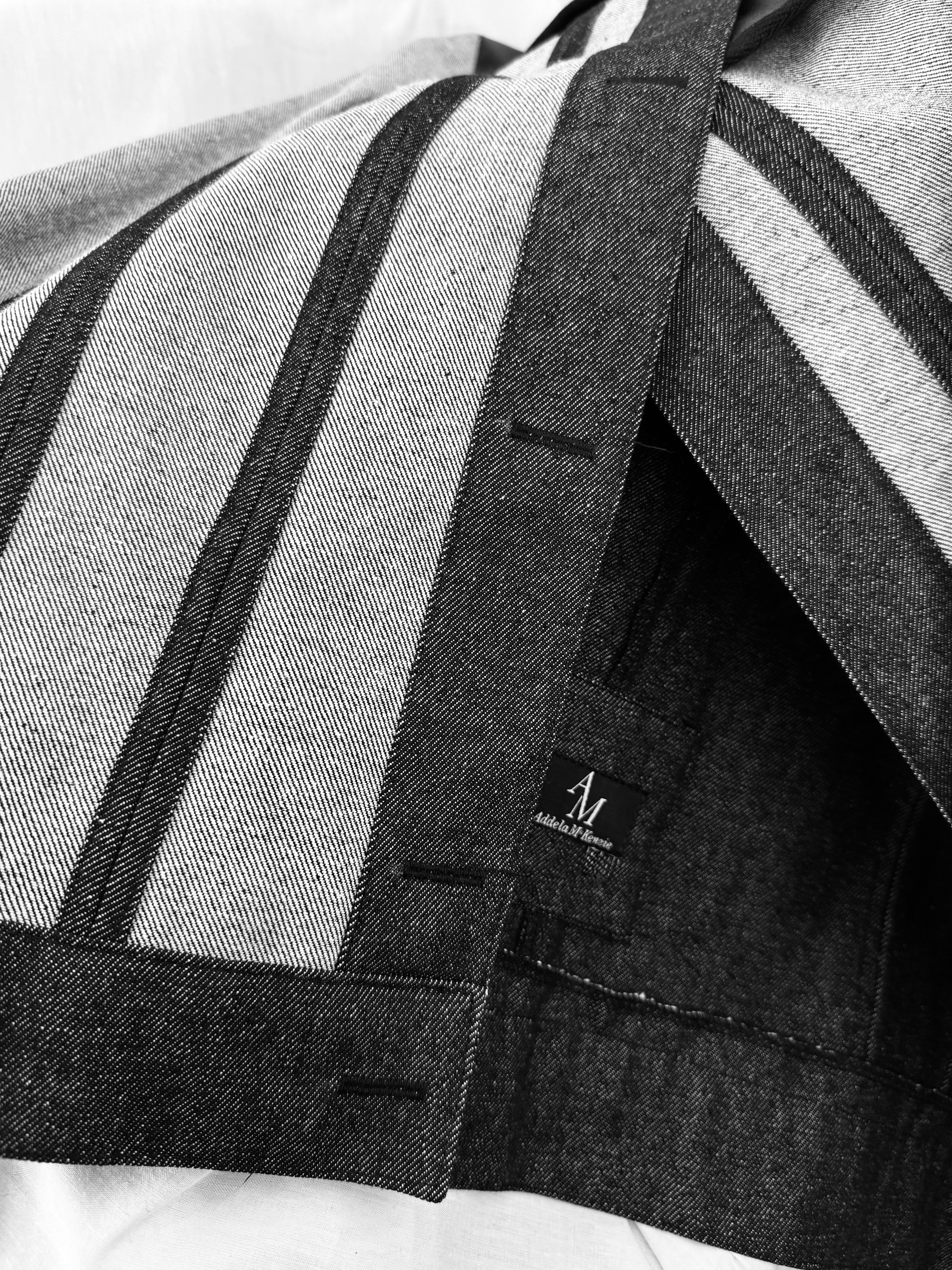 Close detail of a hand-cut seam — raw-edge construction from the Addela McKenzie atelier