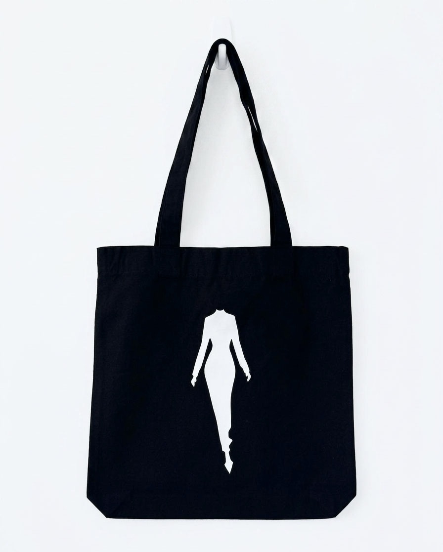 The Silhouette Tote — black cotton tote bag with the white Addela McKenzie woman silhouette